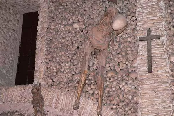 Interior of the Chapel of Bones in Évora, featuring walls lined with human skulls and bones