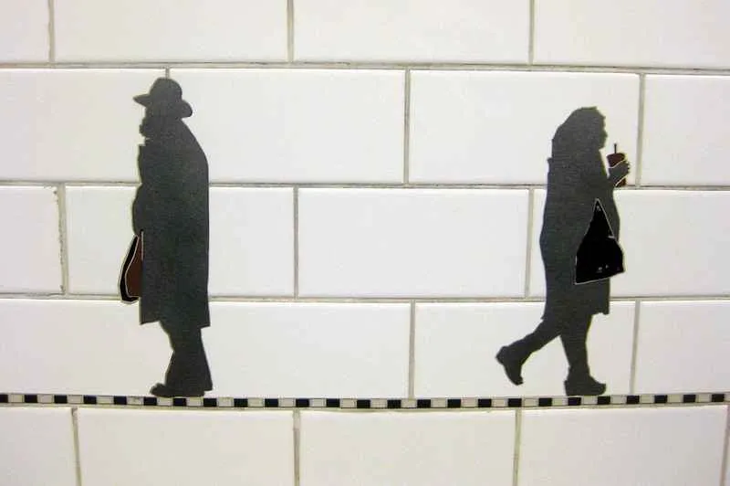 Artistic silhouettes of people carrying items at Prince Street station.