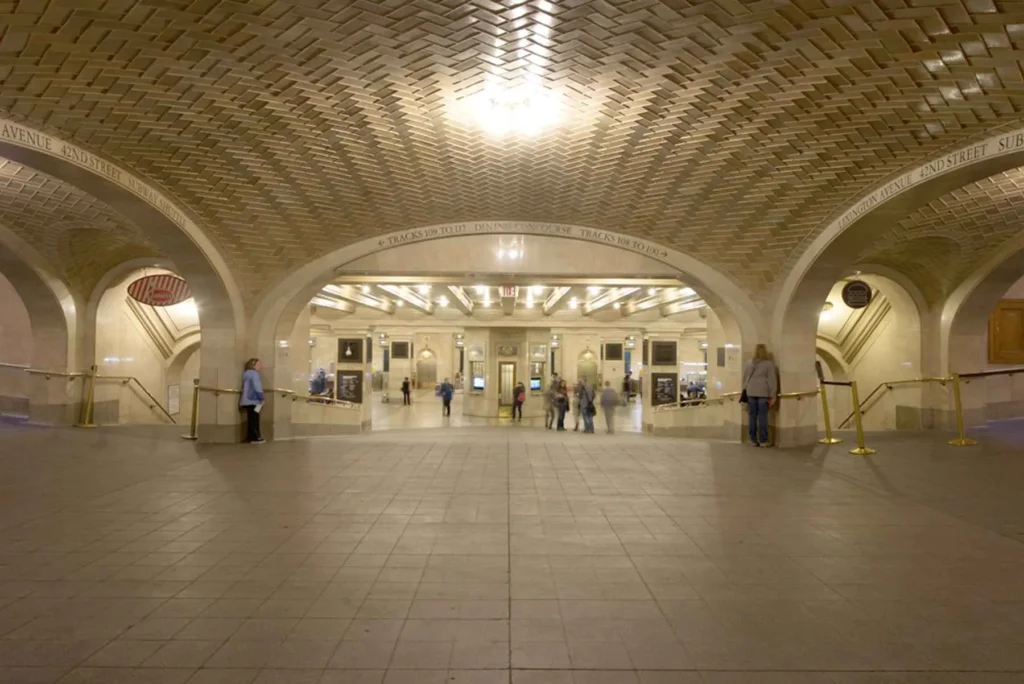 Two people trying out the Whispering Gallery at Grand Central