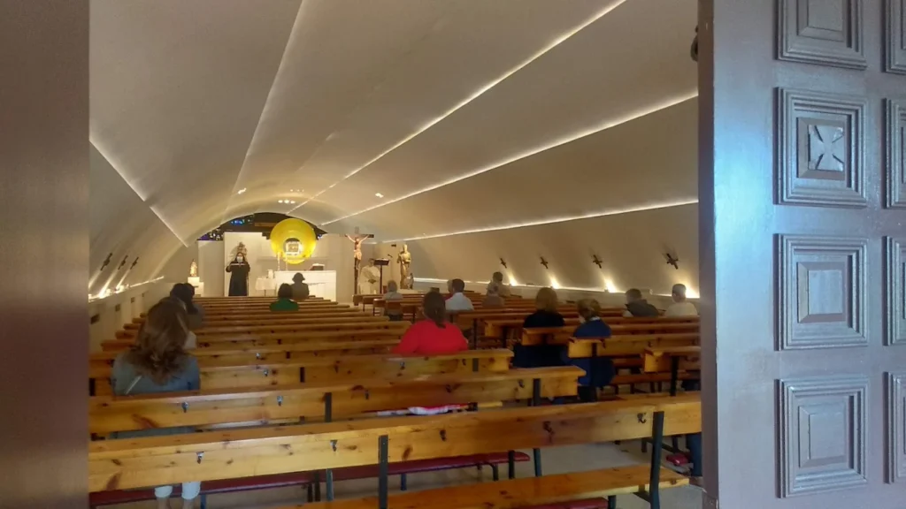 Worshippers entering mass in an unusual chapel beneath the highway