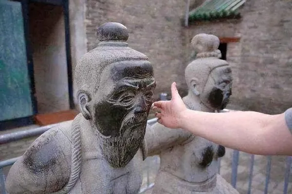 Statues of Qin Hui and his wife at Yue Fei Temple being slapped