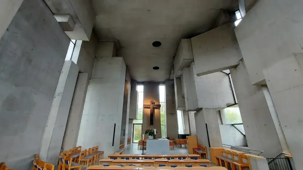 View of the interior of the Wotruba Church in Vienna, with light filtering through the brutalist concrete blocks