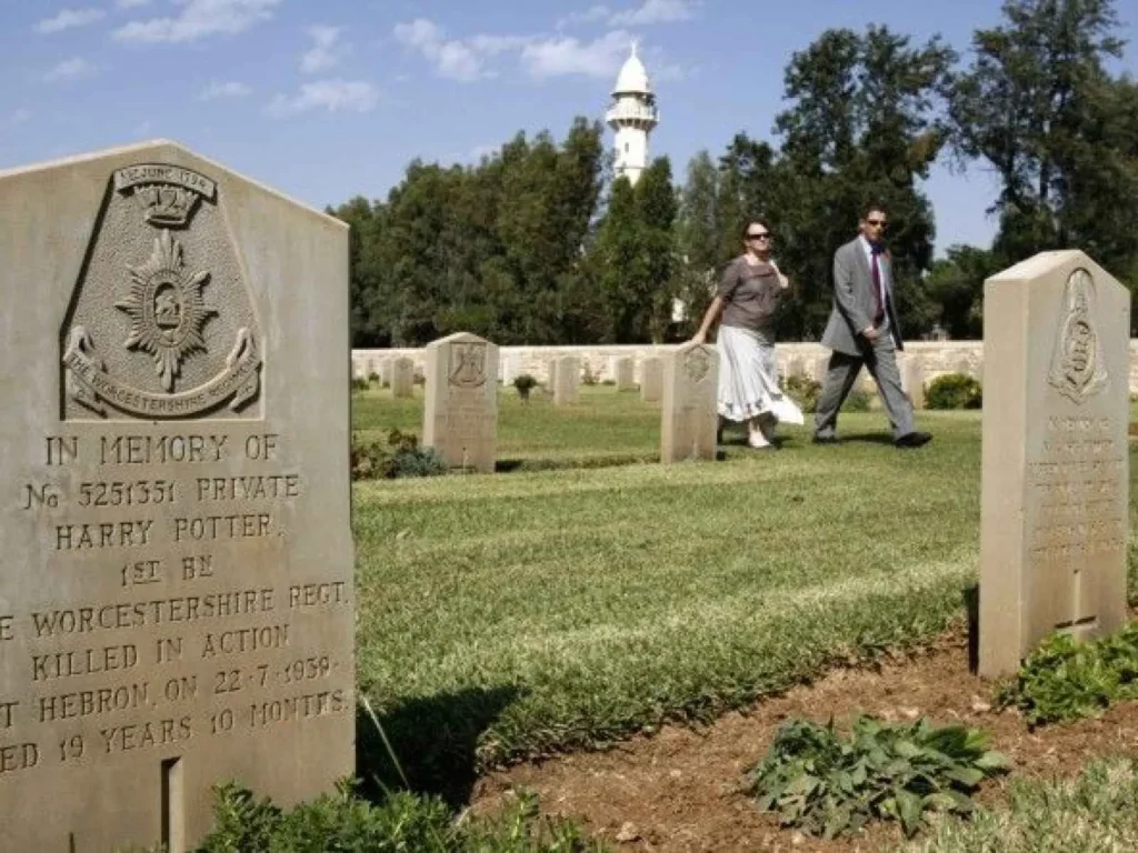 People walk near the grave of a fallen British soldier named Harry Potter before a memorial ceremony at the Commonwealth War Graves Cemetery in Ramle