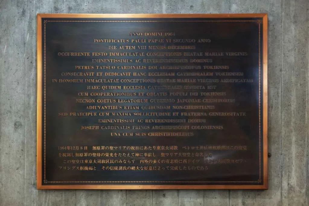 A relief commemorating the support of the Archdiocese of Cologne is installed near the church entrance.