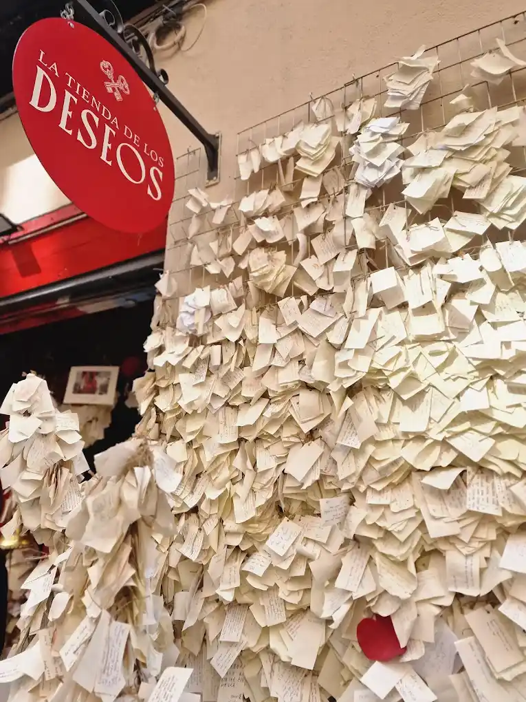 The exterior wall of the wish shop is covered with little notes with wishes written on them.